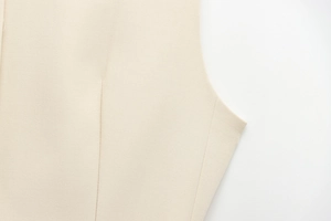 Détail d'un haut sans manches beige montrant la texture sergé et les coutures de pince
