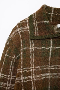 Détail d'un cardigan en maille vintage à carreaux montrant la texture et le col classique
