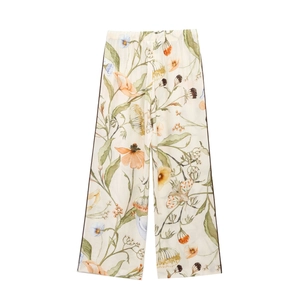 Detail of floral and butterfly print on wide leg trousers with dark side piping