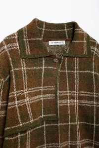 Gros plan du col d'un cardigan en maille à carreaux rétro marron et vert