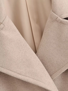 Détail de la texture de laine de qualité et du col à revers beige sur le manteau