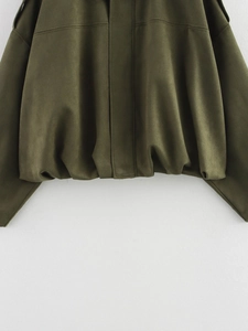 Detail of olive green faux suede jacket featuring elastic hem and flap pocket textures