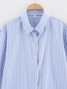 Detail view of blue striped shirt collar and buttons with size S label on a hanger