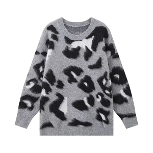 Detailed view of the ribbed cuffs and grey leopard print knit pattern on this cozy sweater