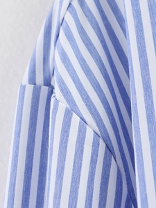 Close-up of blue and white striped shirt shoulder seams and woven cotton fabric texture