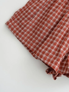 Detail shot of vintage red and white plaid fabric with neat stitching on hem edges