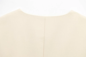 Détail d'un débardeur beige à col rond montrant des coutures propres et un tissu de qualité