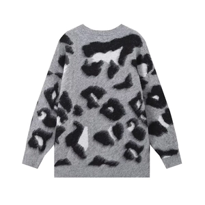 Close-up of soft leopard print knit fabric and ribbed cuffs on a grey winter sweater