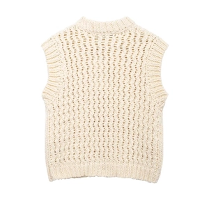 Gros plan détaillé d'un gilet en maille crème montrant la texture et le tissage ajouré
