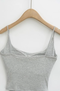 Detailed view of light grey slim-fit tank top with thin straps on a wooden hanger