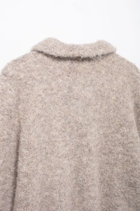 Dettaglio del collo in finta pelliccia e della trama a maglia di questo cardigan beige