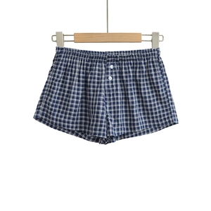 Close-up of blue and white checkered shorts with elastic waistband and decorative buttons