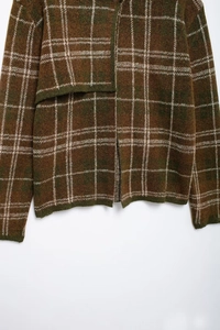 Gros plan du tissu du cardigan en tricot vintage montrant la texture et le motif épais
