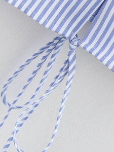 Detailed view of the blue and white striped cotton shirt featuring a thin matching waist tie