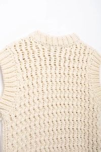 Gros plan sur le gilet en tricot crème avec texture évidée et col rond côtelé élégant