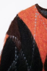 Close-up of multicolor geometric mohair knit sweater with soft fuzzy texture and diamonds
