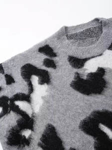 Close-up of gray leopard print knit sweater with ribbed crew neck and fuzzy texture