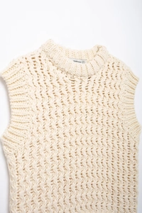Détail de cette veste en tricot crème avec col rond et motif de tissage texturé et ajouré