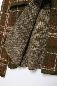 Vue macro détaillée de la maille épaisse à carreaux dans les tons marron et olive
