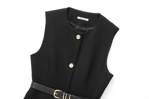 Détail du gilet noir avec boutons dorés en relief et fine ceinture en cuir élégante
