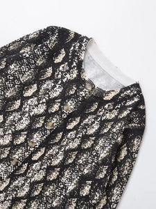 Dettaglio del cardigan in maglia a serpente con colletto a coste e bottoni marmo