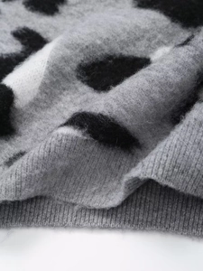 Detail of grey leopard print knit sweater with fuzzy wool texture and ribbed hem