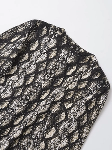Dettaglio di maglione in maglia con stampa a serpente e scollo rotondo classico
