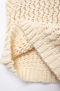 Vue détaillée du motif en maille torsadée et des finitions côtelées du gilet pour femme