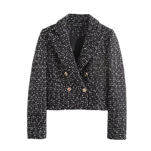 Close-up of textured tweed blazer fabric with golden buttons and designer neck label