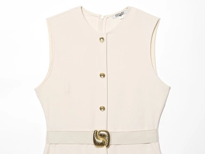 Détail de la robe sans manches crème avec boutons dorés et boucle de ceinture artistique