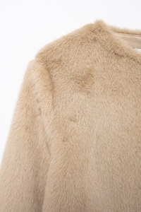 Détail de la texture en fausse fourrure douce et du col sur cette veste courte camel