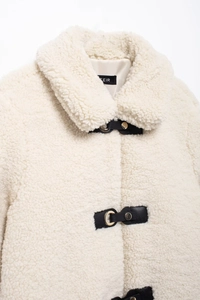 Detailansicht der Teddyjacke mit schwarzem Lederknebelverschluss und goldener Metallschnalle