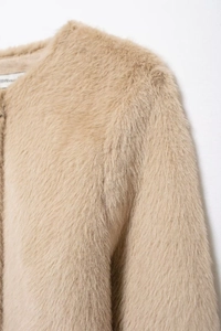 Détail de la texture en fausse fourrure douce et du col de cette veste beige