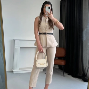 Haut à basque sans manches abricot avec pantalon ajusté assorti et ceinture noire