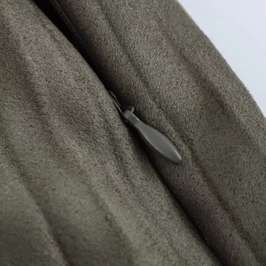 Gros plan sur tissu suédé olive foncé avec une fermeture éclair invisible en forme de goutte