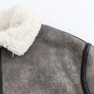 Detalle de chaqueta de ante gris con cuello de borreguillo blanco y adornos en negro