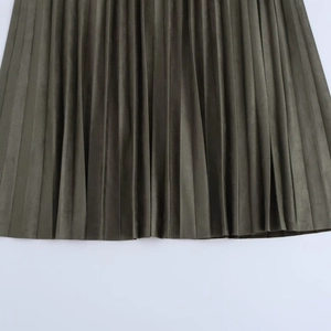 Détail de la jupe midi plissée vert olive montrant la texture en daim et l'ourlet
