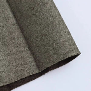 Gros plan détaillé sur la texture du tissu suédé vert olive avec fini velours doux