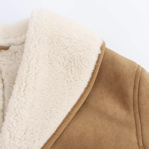 Close-up of winter jacket showing brown suede fabric and thick white faux shearling lining