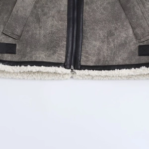 Detalle de chaqueta de ante gris con ribetes de cuero negro y forro de piel sintética blanca