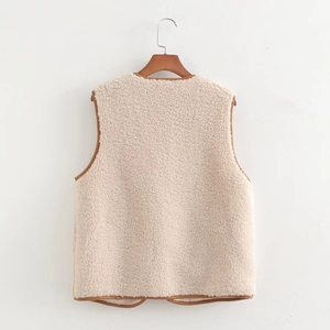 Detail view of the back of a beige fleece vest with brown faux leather trim and high texture