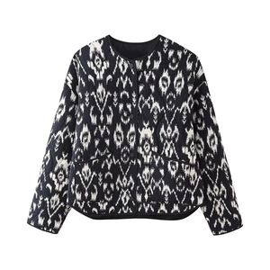 Detail of diamond quilted texture and snap buttons on black and white geometric jacket