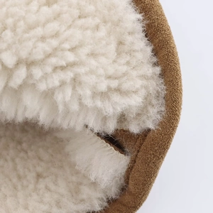 Close-up of warm faux shearling lining and brown suede texture on winter boots