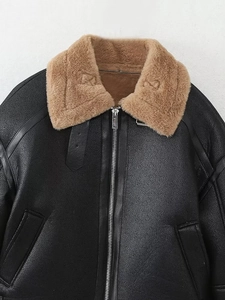 Détail d'une veste en similicuir noir avec un col épais en faux mouton de couleur kaki