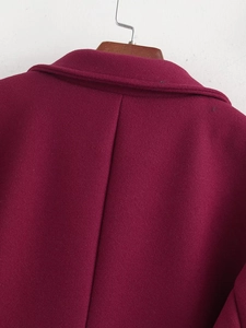 Detail view of the back seams and neckline stitching of the burgundy wool coat