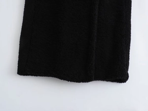 Detailed macro view of black fleece fabric texture on a long winter coat sleeve