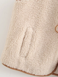 Detail shot of soft cream sherpa fleece fabric with brown piping on side pocket