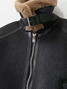 Détail de la boucle et du zip sur le col d'une veste motard noire en peau lainée