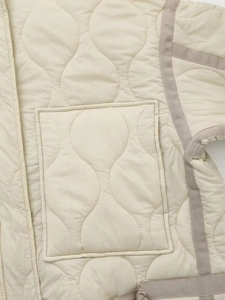 Détail d'une veste matelassée à vagues avec poche plaquée et bordure contrastée
