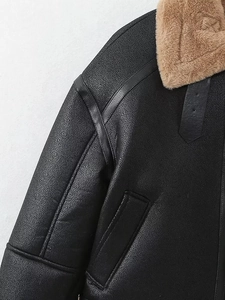 Gros plan sur le cuir noir texturé avec col en fausse fourrure marron et boucles en métal